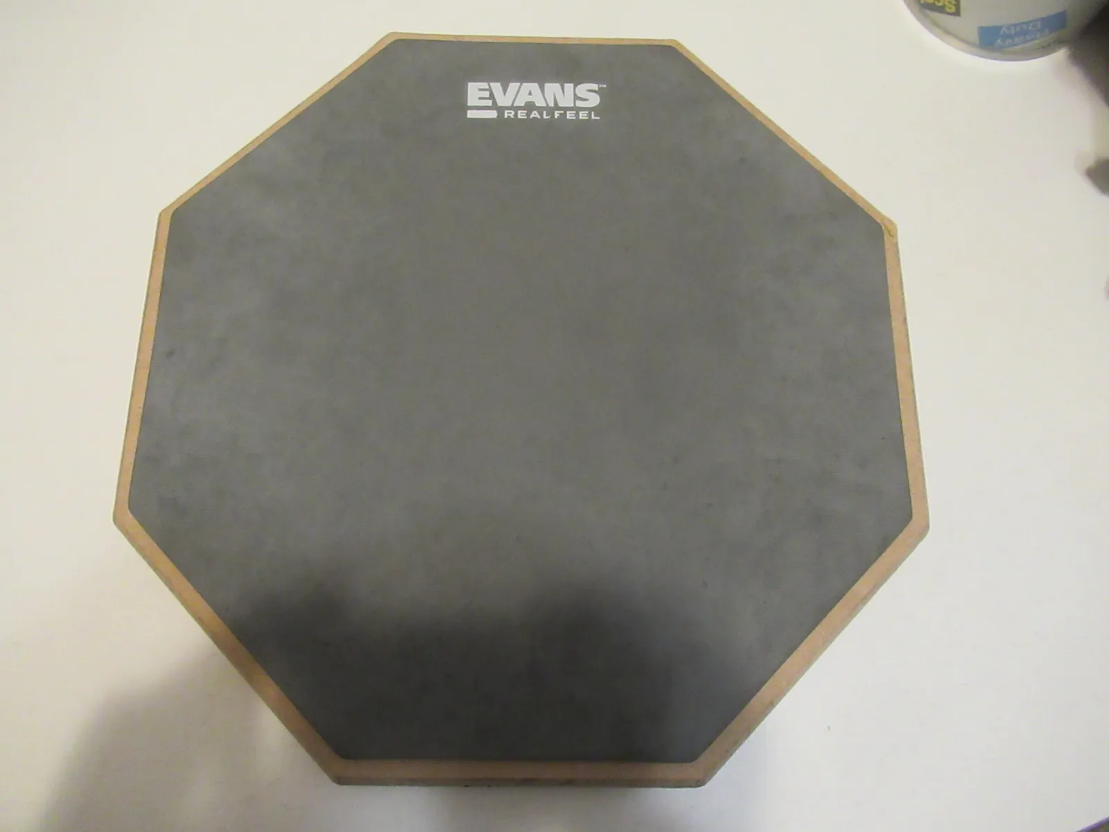 Gray EVANS RealFeel octagonal practice pad with a wooden edge, photographed on a table